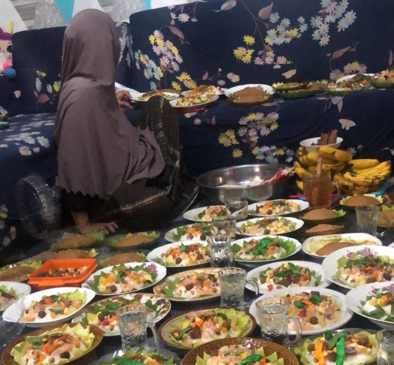 Sugiati Deng Sunggu, sedang menata bubur Asyura di atas piring, siap untuk dibagikan ke tetangga terdekat. Foto: duniacerita